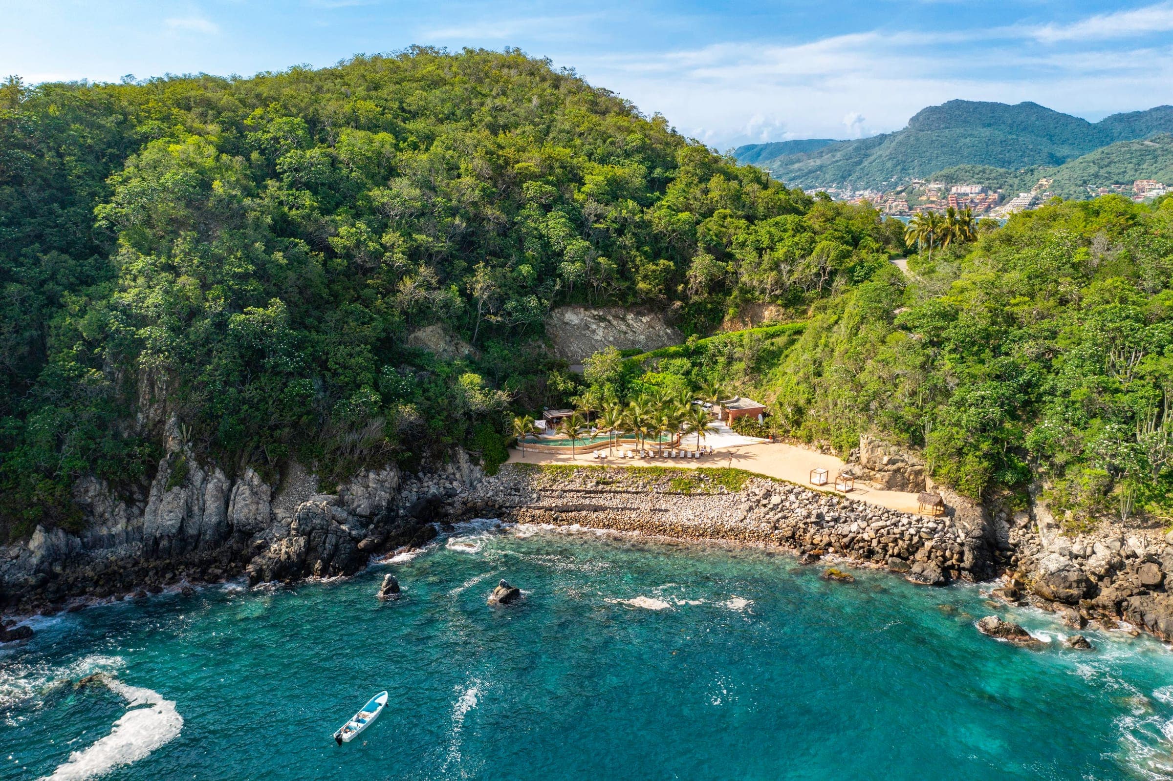 The cove at Punta Garrobo from the air: turquoise water, the beach club and the green hillside